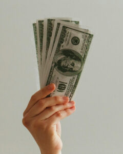 Save Money Picture of a hand holding $100 bills.